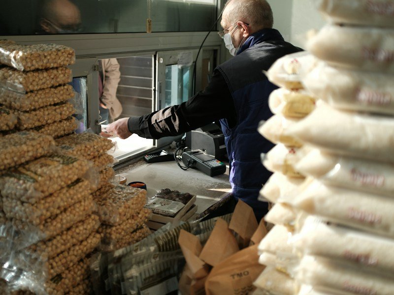 Commercial nursery technician blending raw organic fertilizer inputs in a stainless steel ribbon mixer