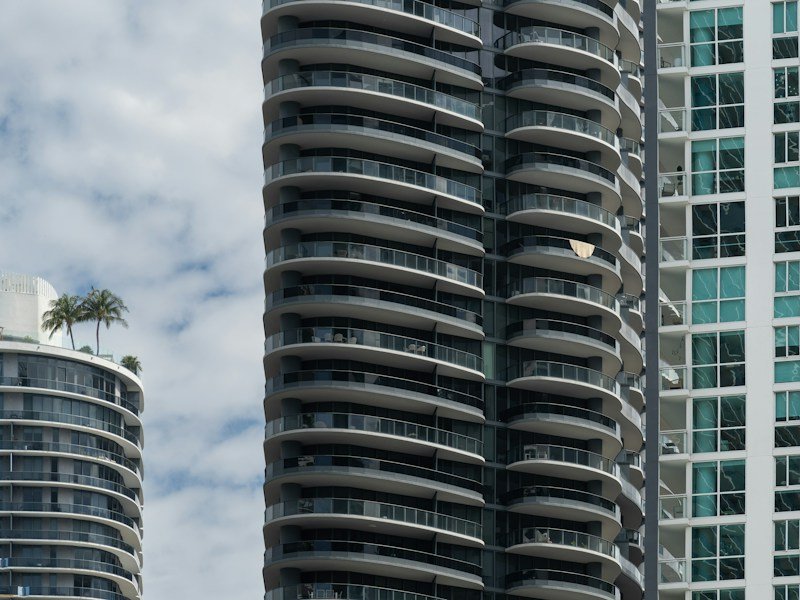 Frameless laminated glass windbreak panels installed on a high rise balcony overlooking a downtown skyline