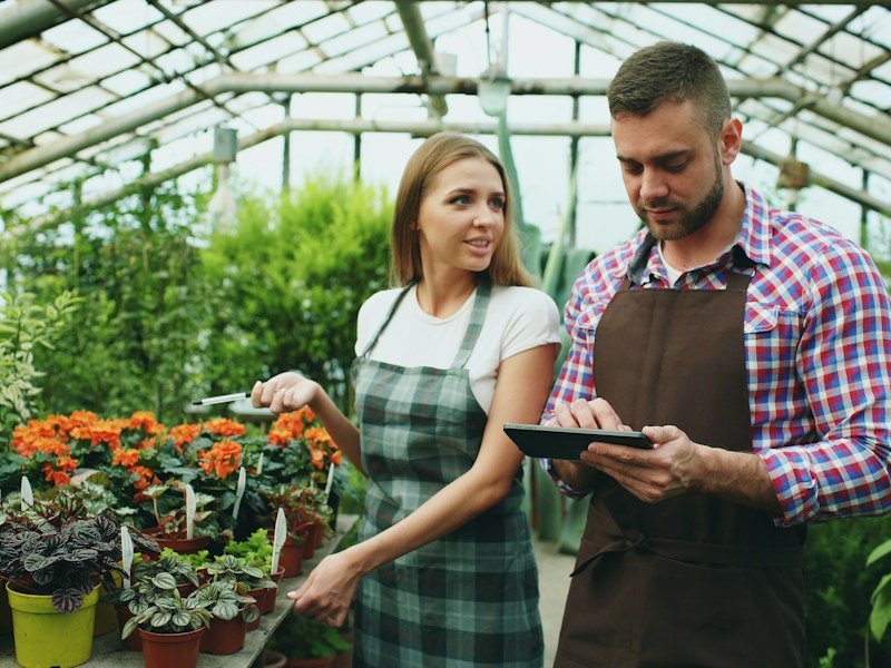 Garden center staff member reviewing a container gardening course curriculum and starter kit with a customer