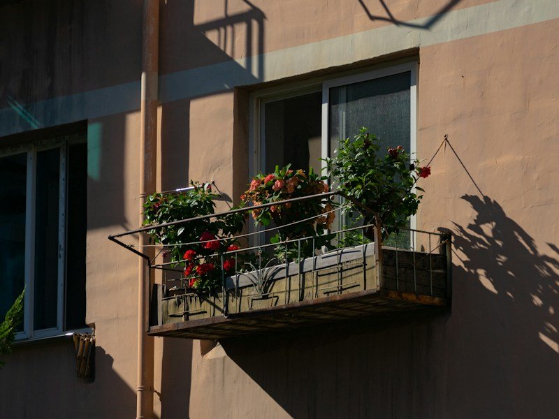 Property manager reviewing a renter friendly balcony vegetable garden kit with a resident at a mid-rise apartment building